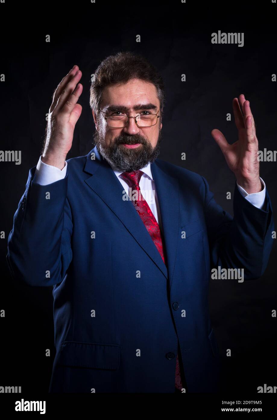 Mature businessman dressed in blue suit with red tie studio portrait ...