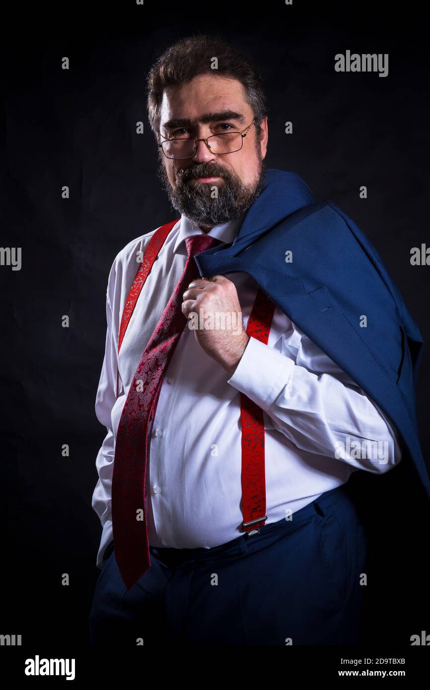 Mature businessman dressed in blue suit with red tie studio portrait ...