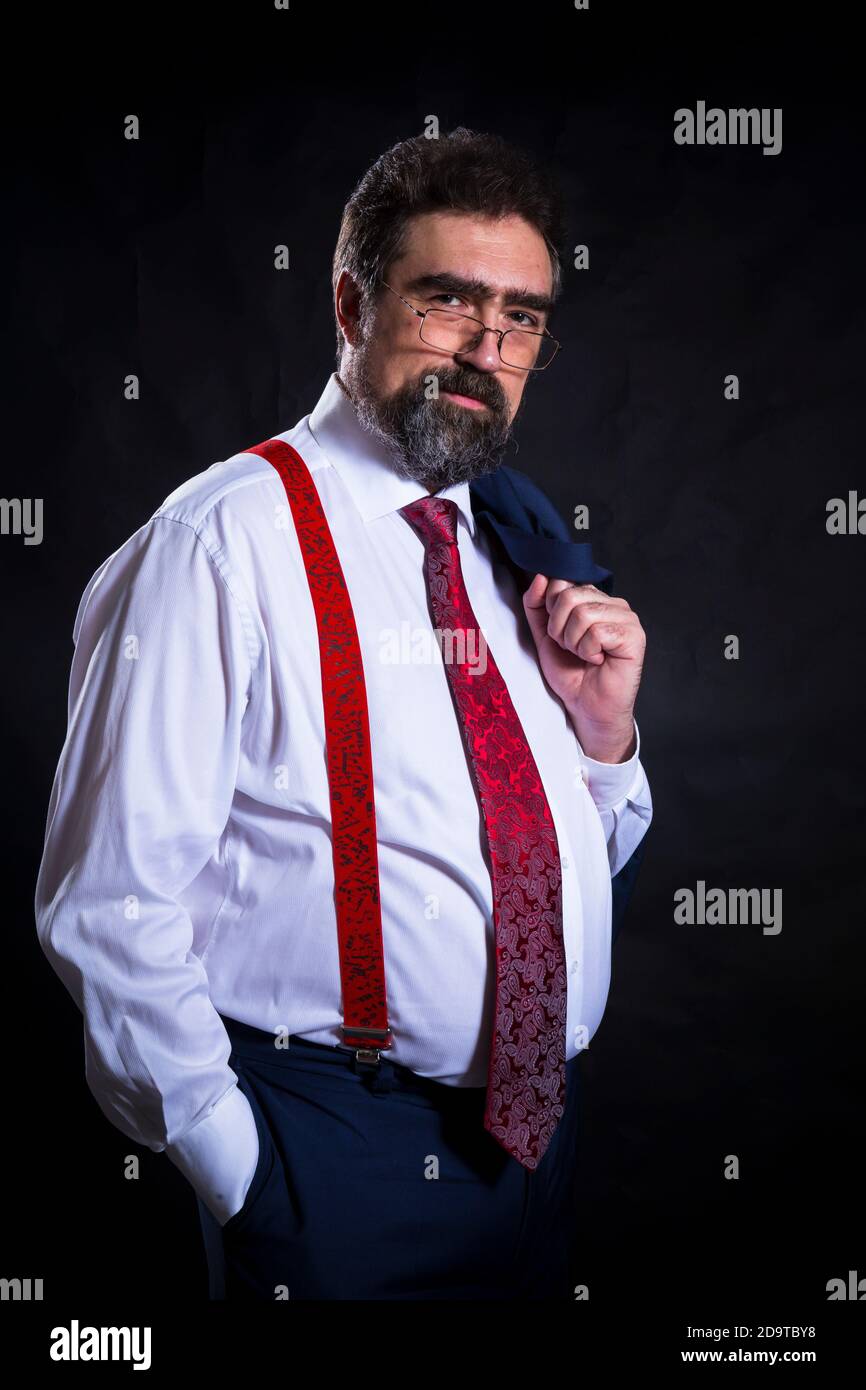 Mature businessman dressed in blue suit with red tie studio portrait ...