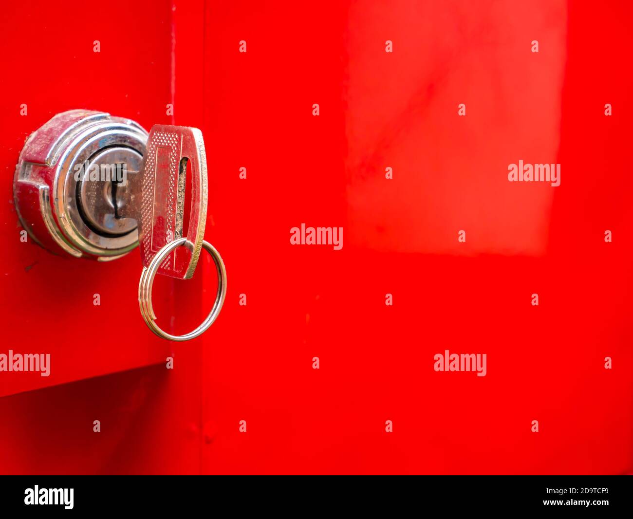 Key in the keyhole on a red background. Stock Photo