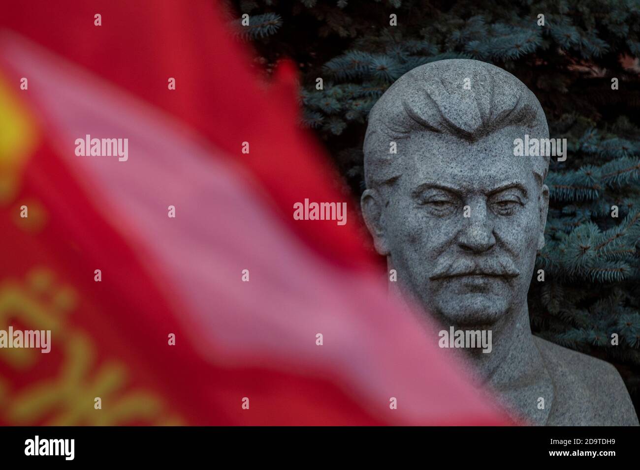 Bust of Joseph Stalin in the background of a Pine Tree at the Kremlin Wall Necropolis on Red Square in the center of Moscow, Russia Stock Photo