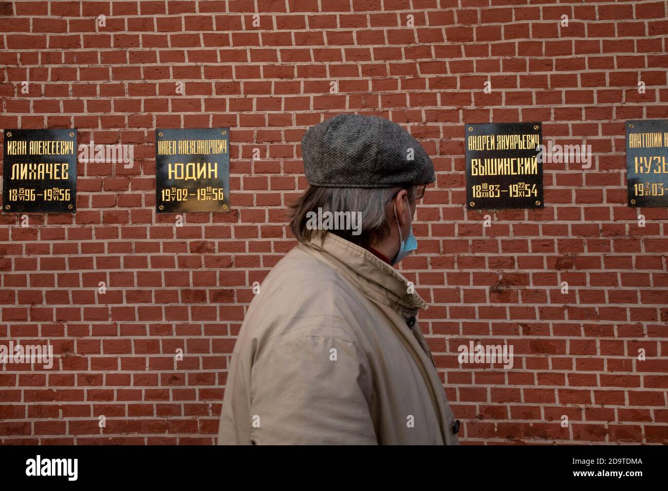 Moscow, Russia. 7th of November, 2020 A man looks at banners with names of soviet politics at the Kremlin wall where the Soviet state leaders are buried, in central Moscow, Russia Stock Photo