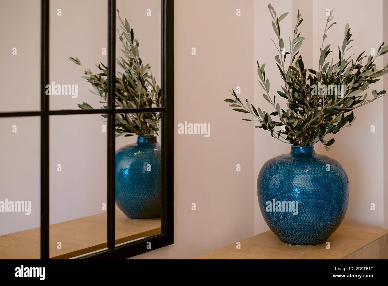 Blue vase stands near the mirror in the interior Stock Photo