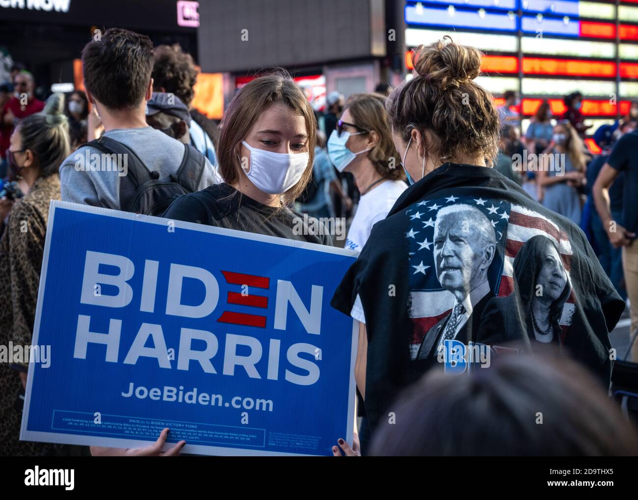 New York, USA. 7th Nov, 2020. People wear face masks as they celebrate in New York City's Times Square after news broke out that former vice-president Joe Biden won the US presidential elections. Biden defeated President Donald Trump to become the 46th president of the United States and Kamala Harris will be the first female vice-president. Credit: Enrique Shore/Alamy Live News Stock Photo
