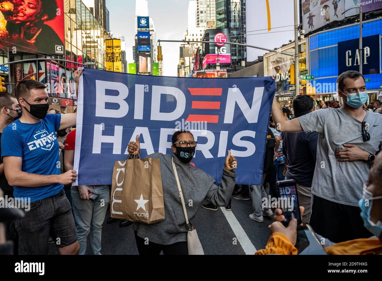 New York, USA. 7th Nov, 2020. People wear face masks as they celebrate in New York City's Times Square after news broke out that former vice-president Joe Biden won the US presidential elections. Biden defeated President Donald Trump to become the 46th president of the United States and Kamala Harris will be the first female vice-president. Credit: Enrique Shore/Alamy Live News Stock Photo