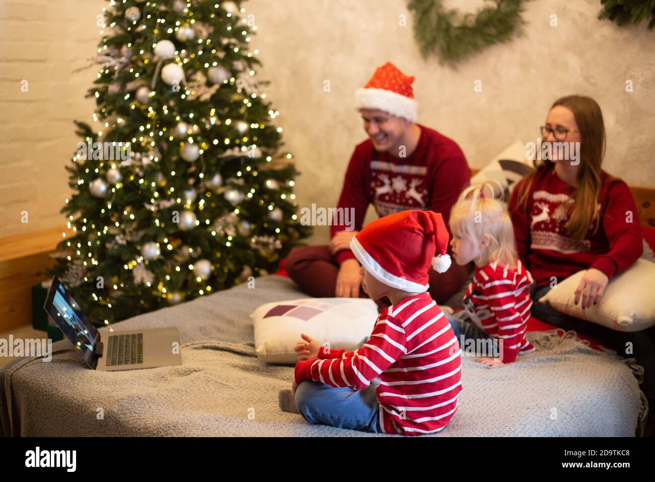 Cheerful children talking to Santa Claus on video chat at Christmas Stock Photo