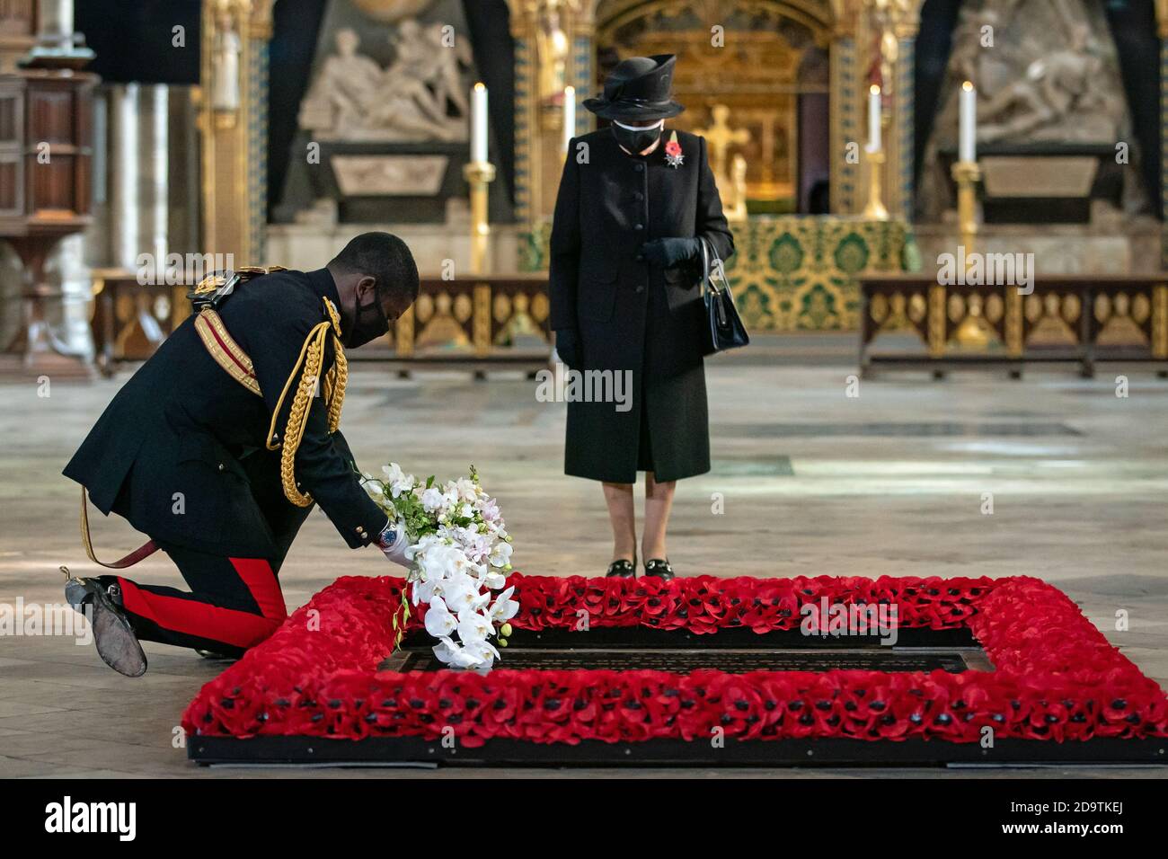 The Queen's Equerry, Lieutenant Colonel Nana Kofi Twumasi-Ankrah, places a bouquet of flowers at the grave of the Unknown Warrior on behalf of Queen Elizabeth II (centre) during a ceremony in London's Westminster Abbey. Stock Photo
