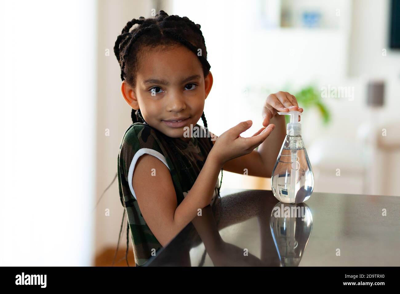 Black African American children hand using antibacterial antiseptic hand sanitizer gel Stock Photo