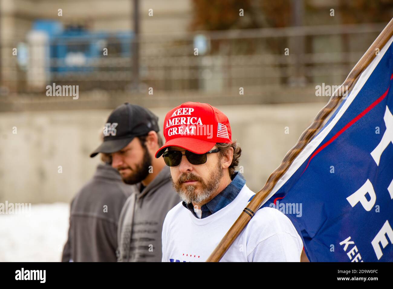 Helena, Montana / Nov 7, 2020: Pro-Trump supporter protesting at 'Stop the Steal' rally at the Capitol wearing Make America Great Again red hat agains Stock Photo