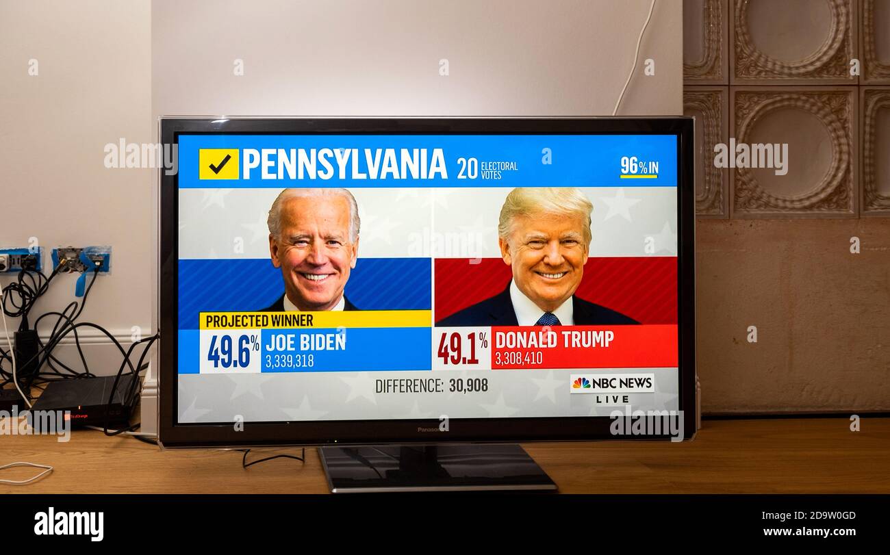 Paris, France - Nov 7, 2020: Living room tv on the wooden floor featuring latest news that Democratic presidential nominee Joe Biden has seemingly won the election with Pennsylvania votes Stock Photo