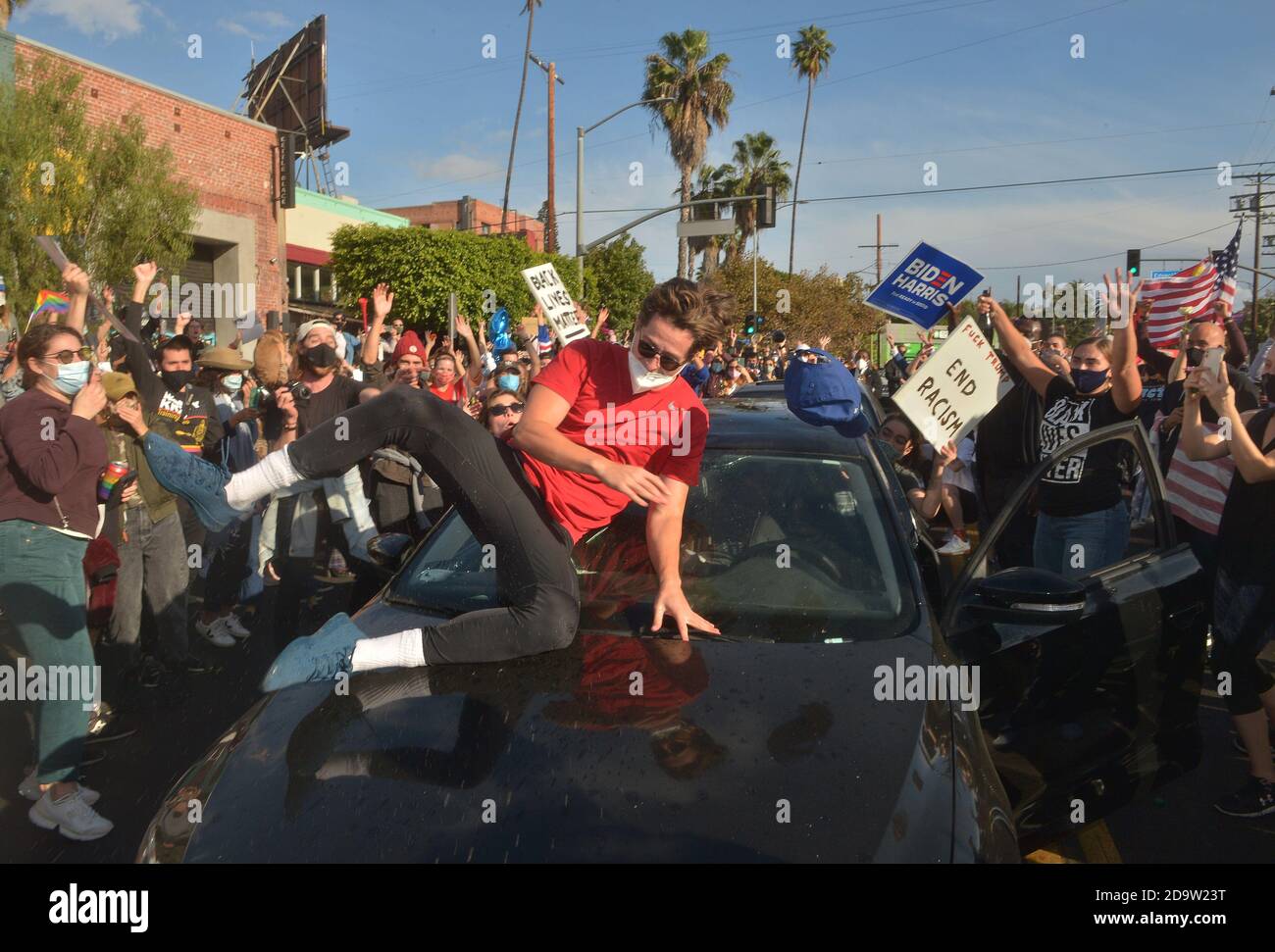 A man breaks his windshield upon slipping on the roof of his car as residents celebrate after several news organizations called the presidential election for Joe Biden in the Silver Lake section of Los Angeles on Saturday, November 7, 2020. Biden defeated President Donald Trump to become 46th president of the United States.  Photo by Jim Ruymen/UPI Stock Photo