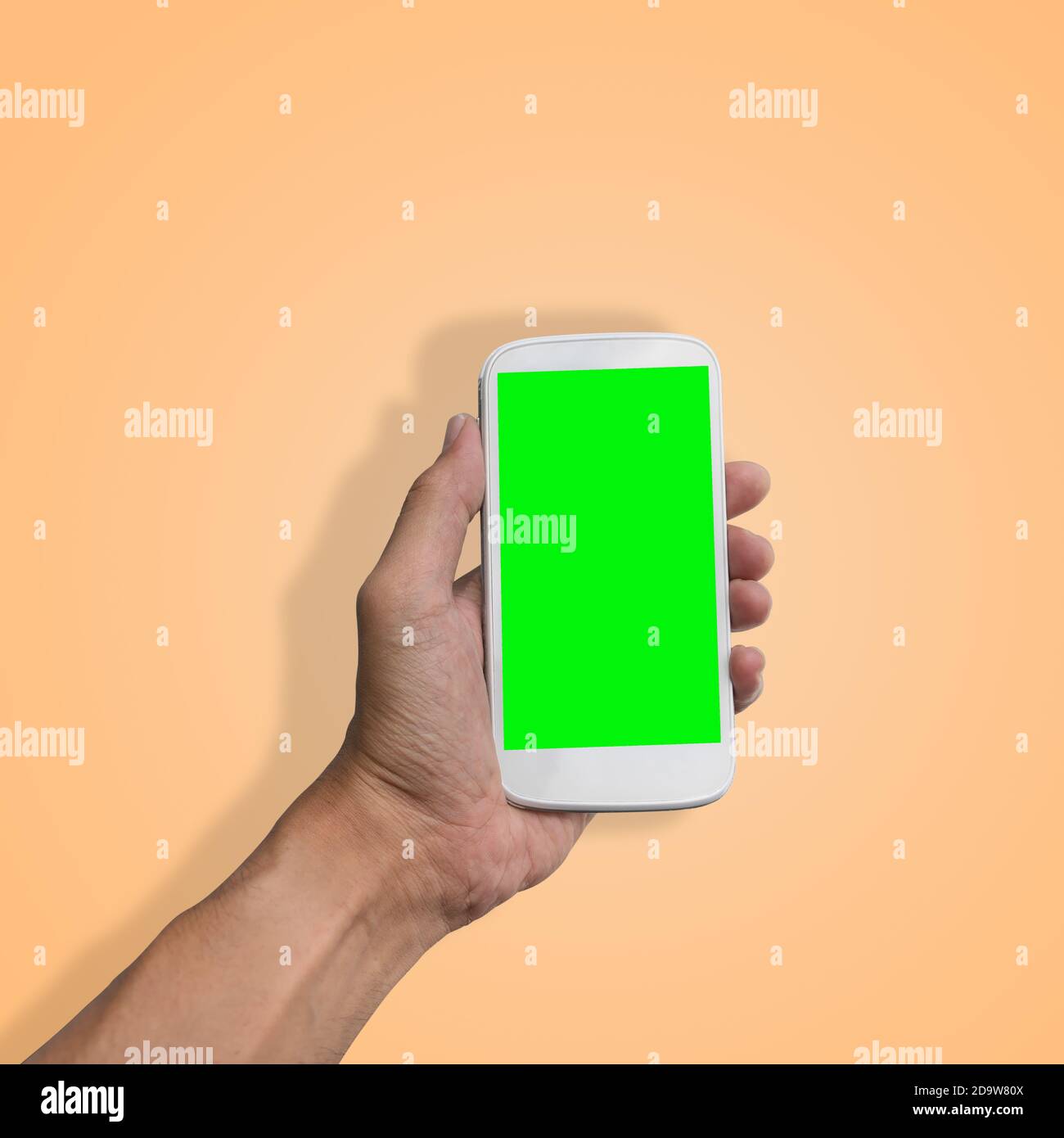 Hand holding smart-phone with green screen isolated on beautiful pastel ...
