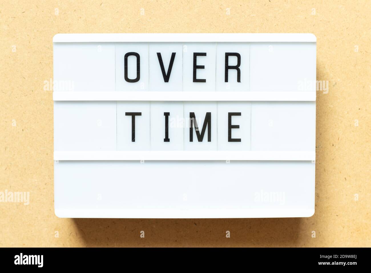 Lightbox with word overtime on wood background Stock Photo