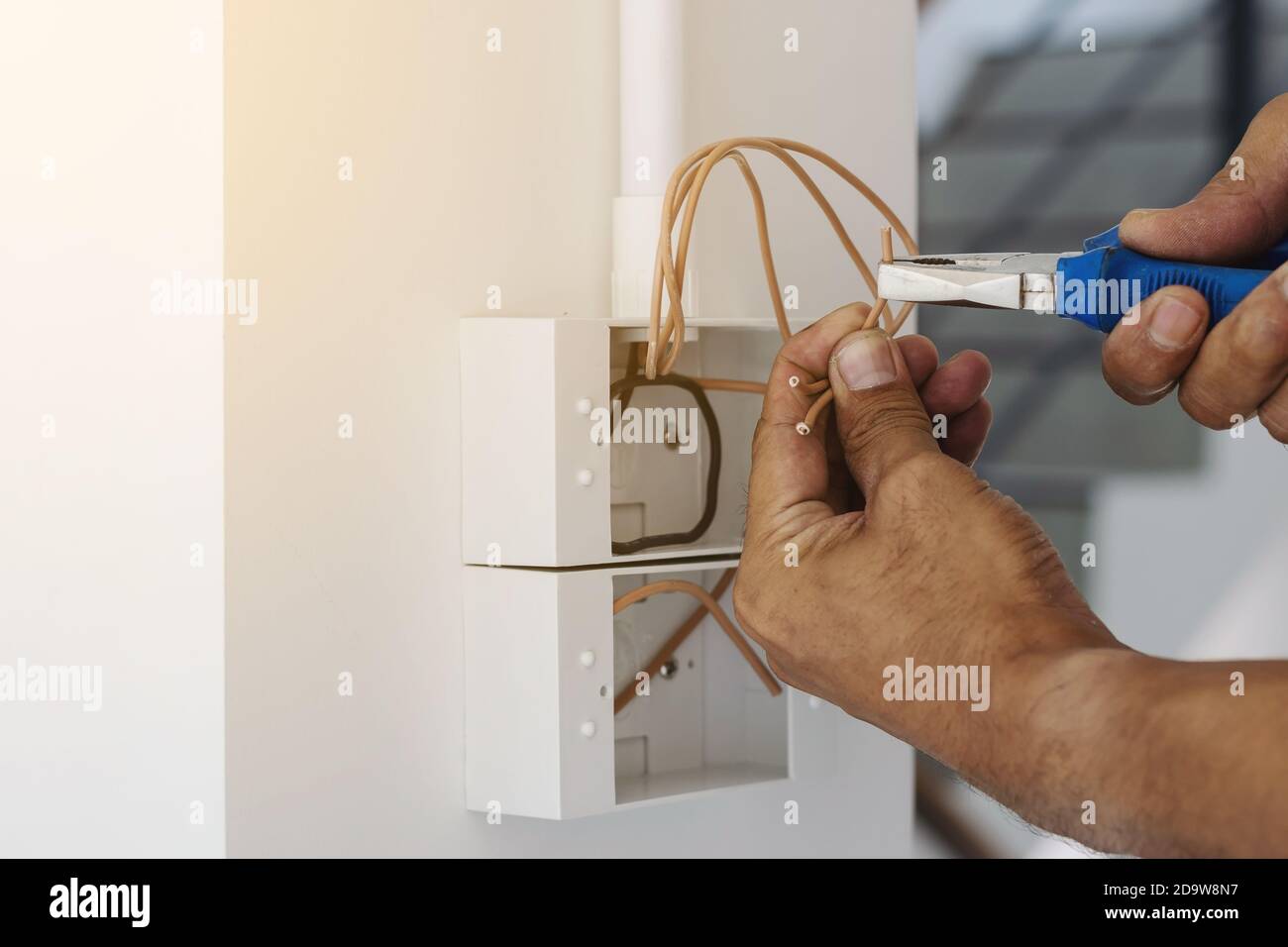 Electricians are using a pliers wrench to install the power plug on the