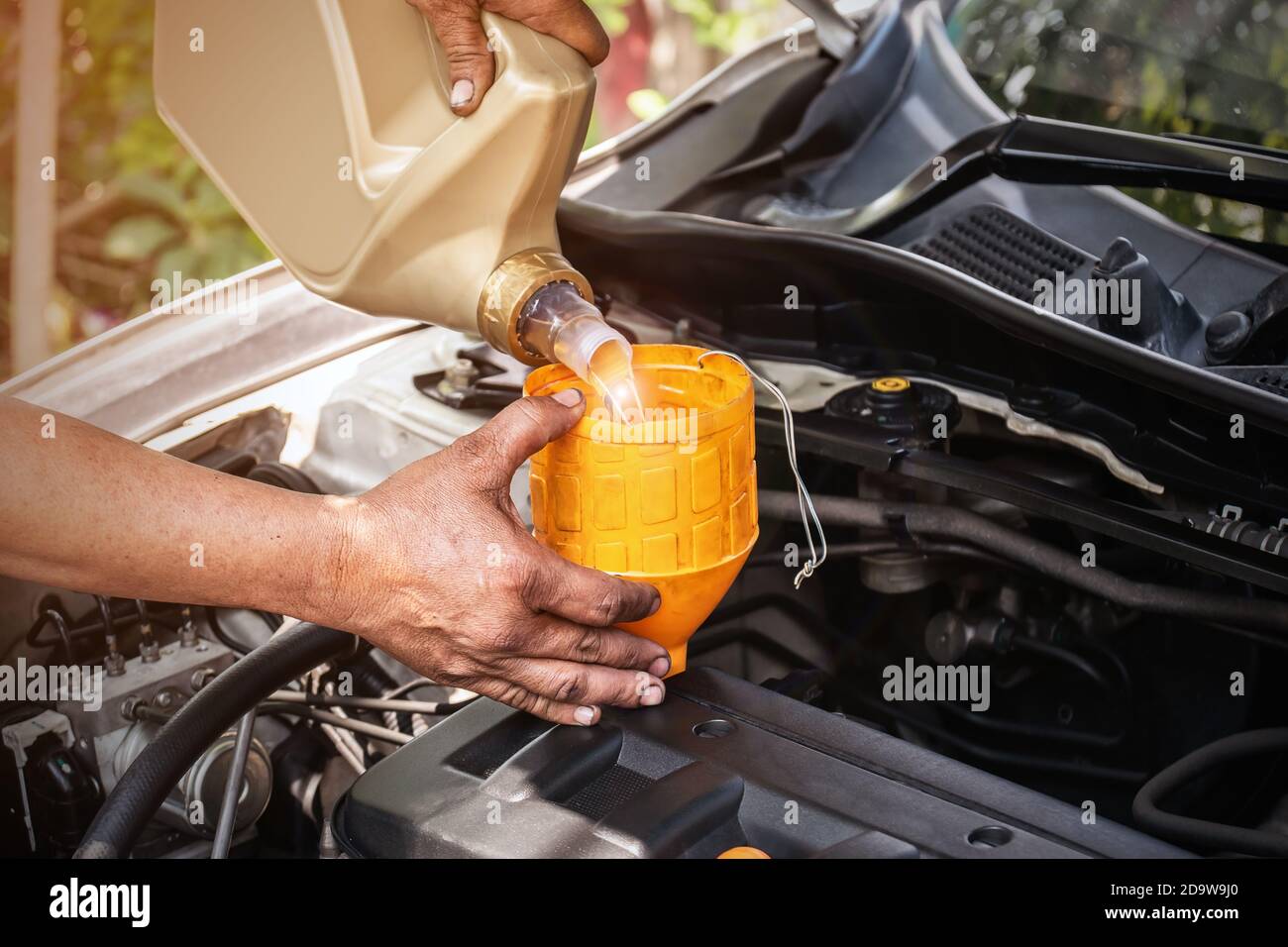 The car mechanic is adding oil to the engine, Automotive industry and ...