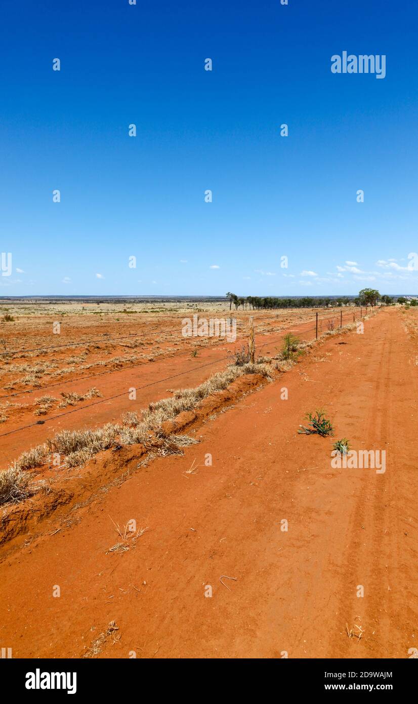 Flat orange drought effected land in central Queensland south of Charters Towers. Australian Outback. Stock Photo
