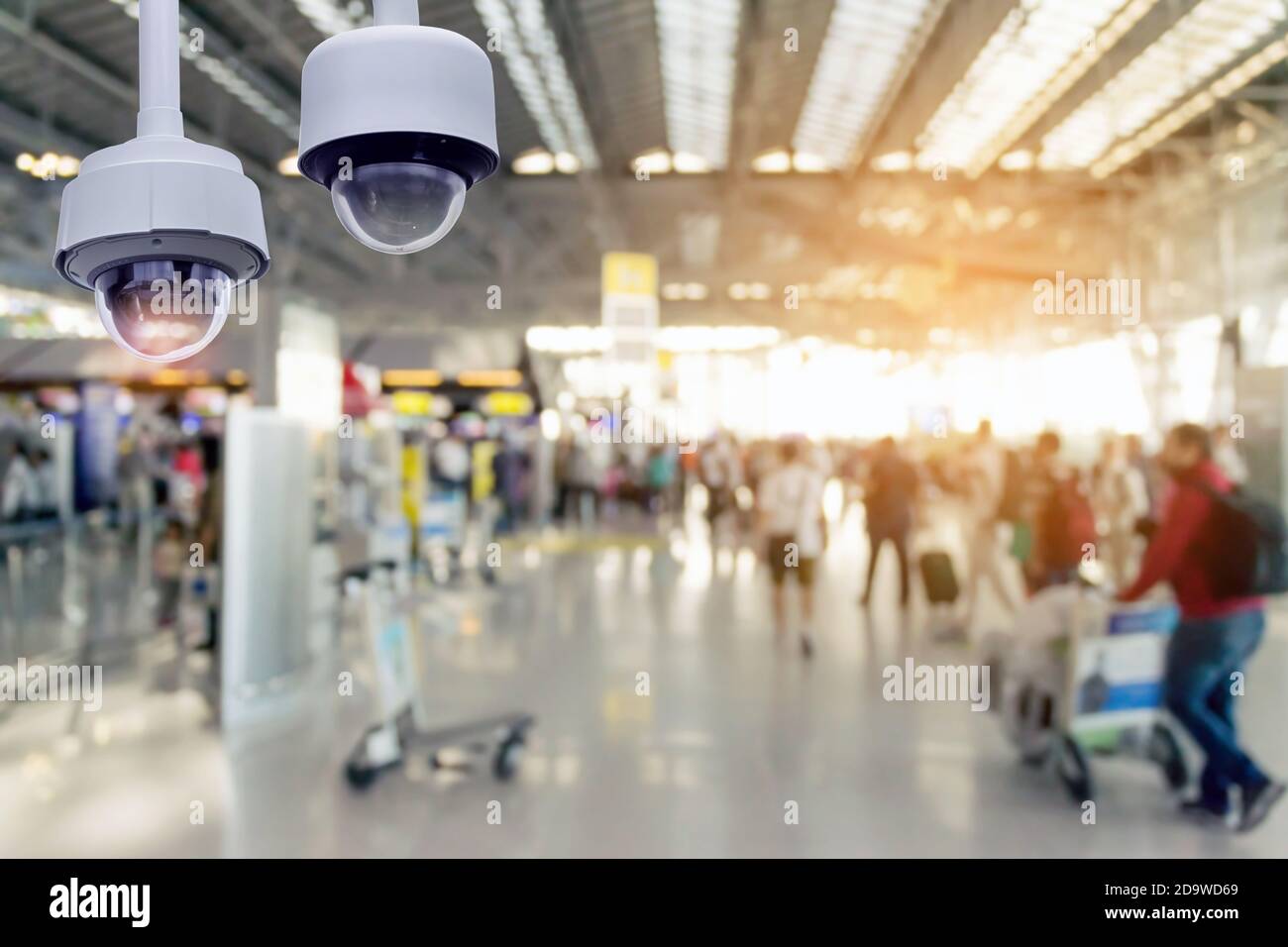 Closeup CCTV security camera on blurred inside the airport terminal background. Stock Photo