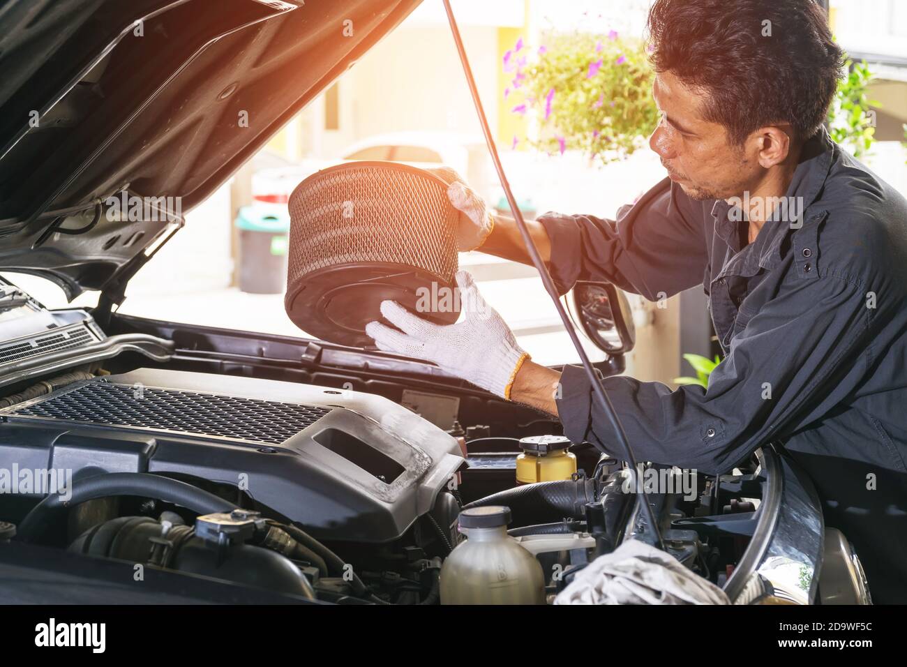 The technician removes the car's air filter for inspection and cleaning, Automotive industry and garage concepts. Stock Photo