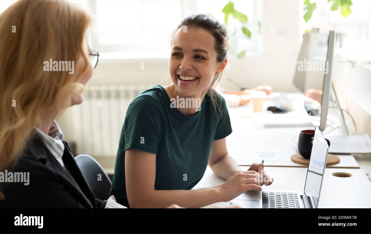 Happy smiling female trainee discussing business ideas with adult trainer Stock Photo