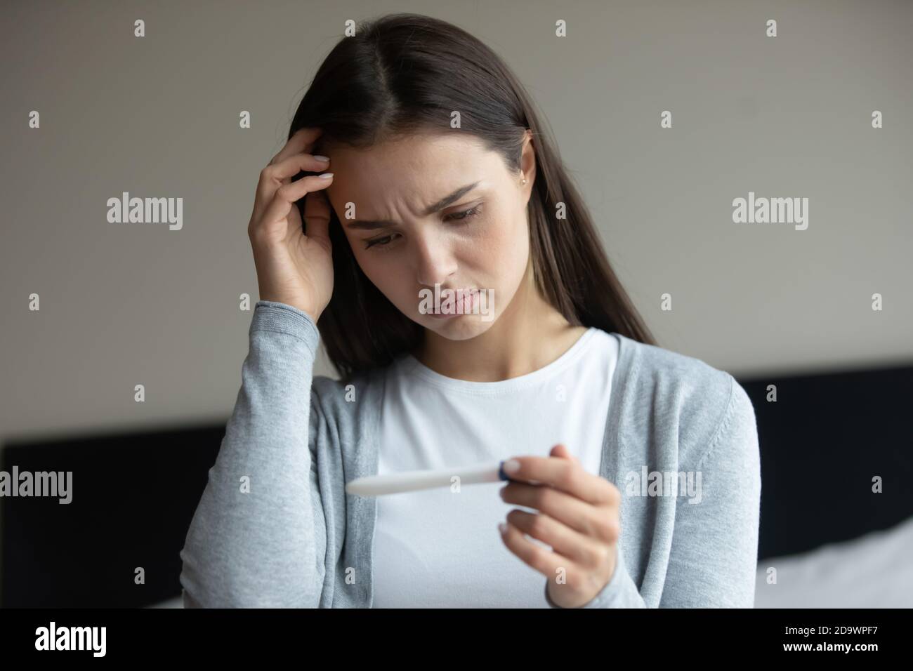 Sad woman getting negative result of pregnancy test after ivf Stock Photo
