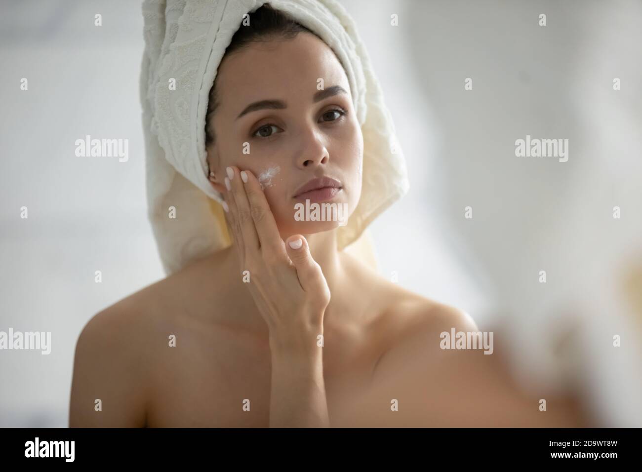Careful young woman with sensitive skin applying cream on chick Stock Photo