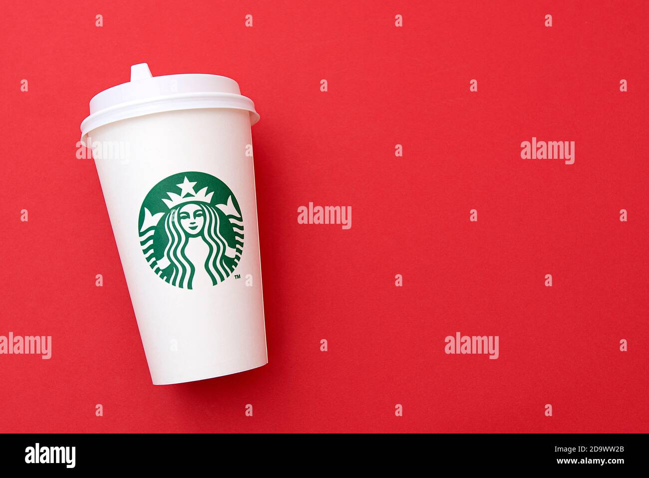 BERLIN - NOV 8: Starbucks Paper Cup. Starbucks Coffee with Logo Mermaid isolated on red background in Berlin on November 8. 2020 in Germany Stock Photo