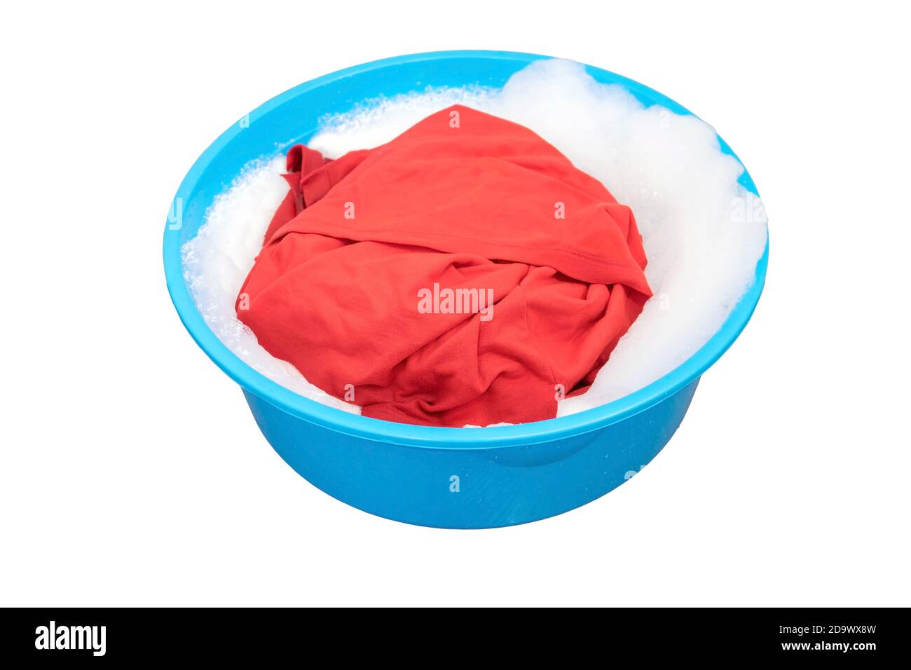 Red shirt soaked in washing powders in the plastic basin. Stock Photo
