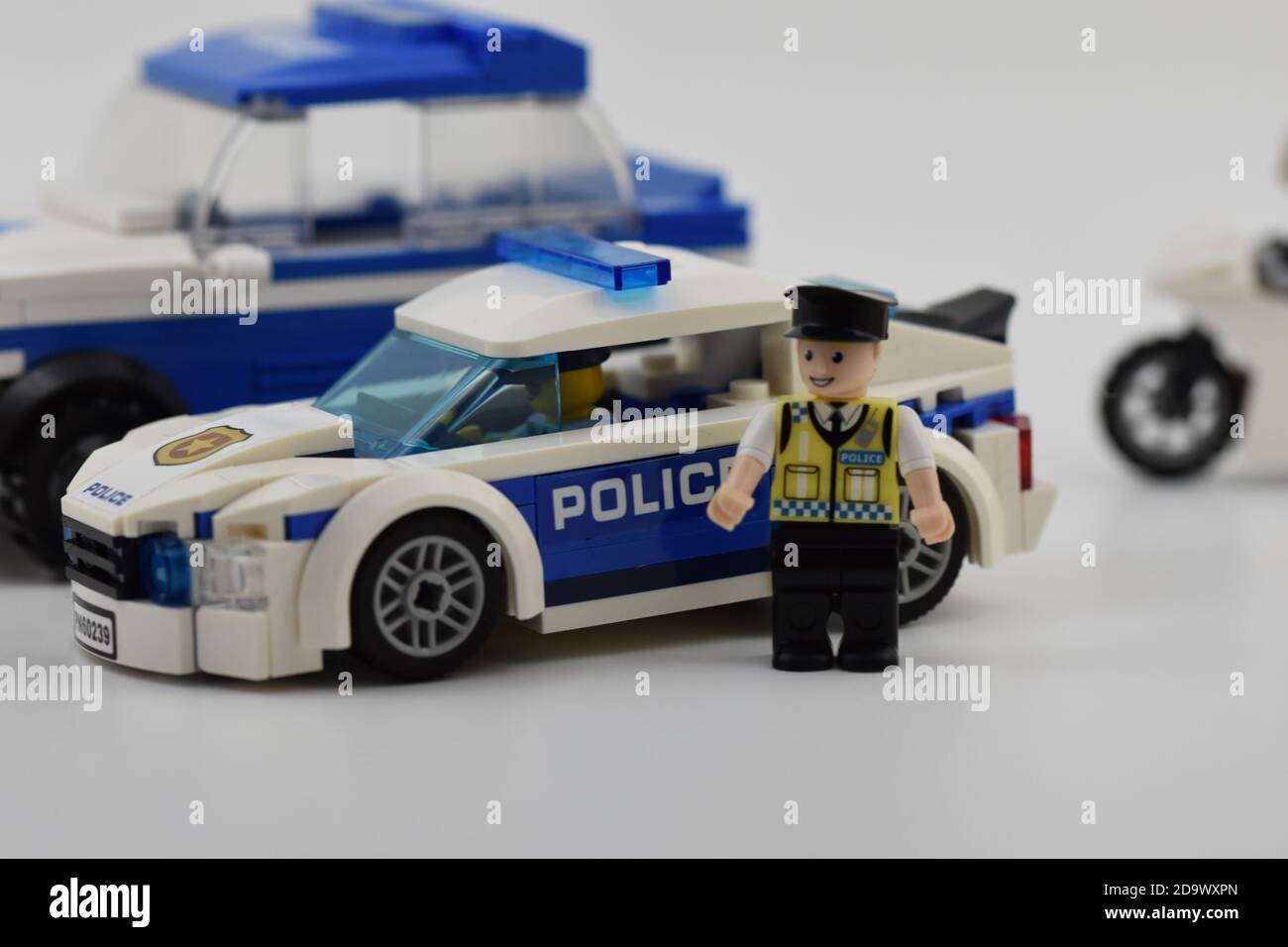 A Wilko Blox mini figure of a Policeman stood next to a Lego Police car  with another Police vehicle in the background which is white Stock Photo -  Alamy