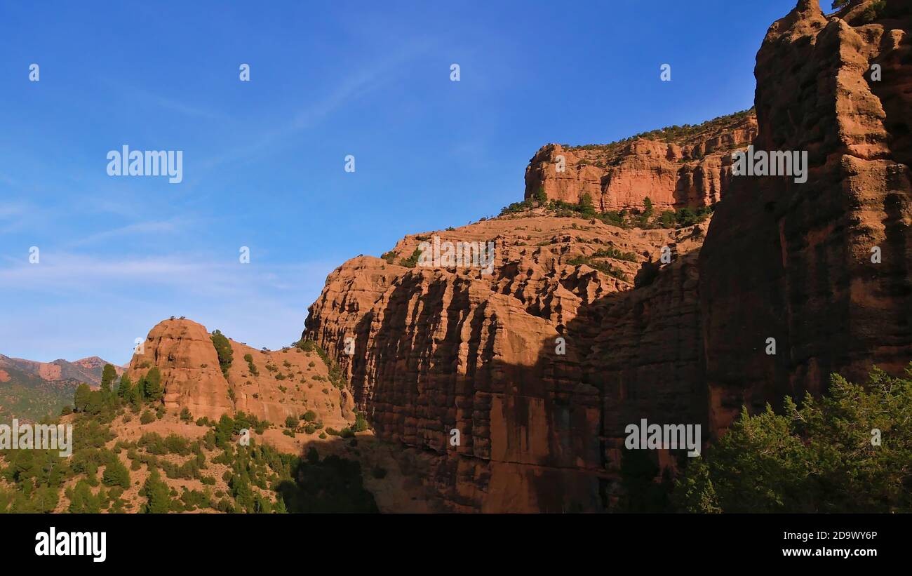 Majestic pancake formed rock formations of popular cathedrale imsfrane near Tilouguite, Morocco with coniferous trees on a hike in winter time. Stock Photo
