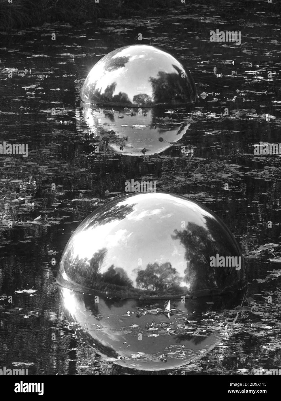 Art and nature - Big silver balls in the water show the world Stock