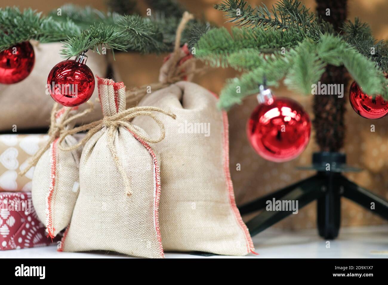 Wrapped gifts under the Christmas tree. Canvas bags, surprise gifts for children Stock Photo
