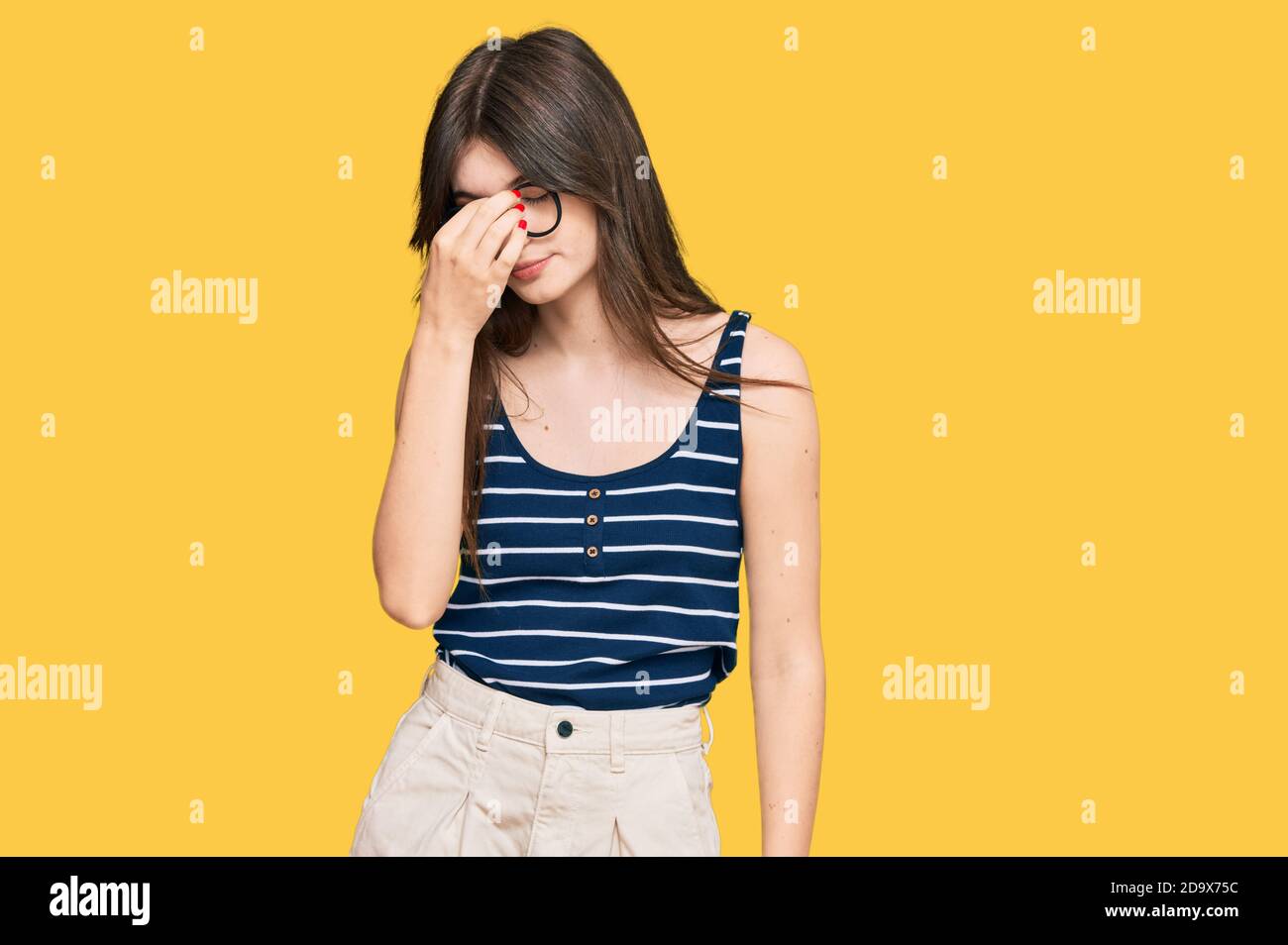 Young beautiful caucasian girl wearing casual clothes and glasses tired