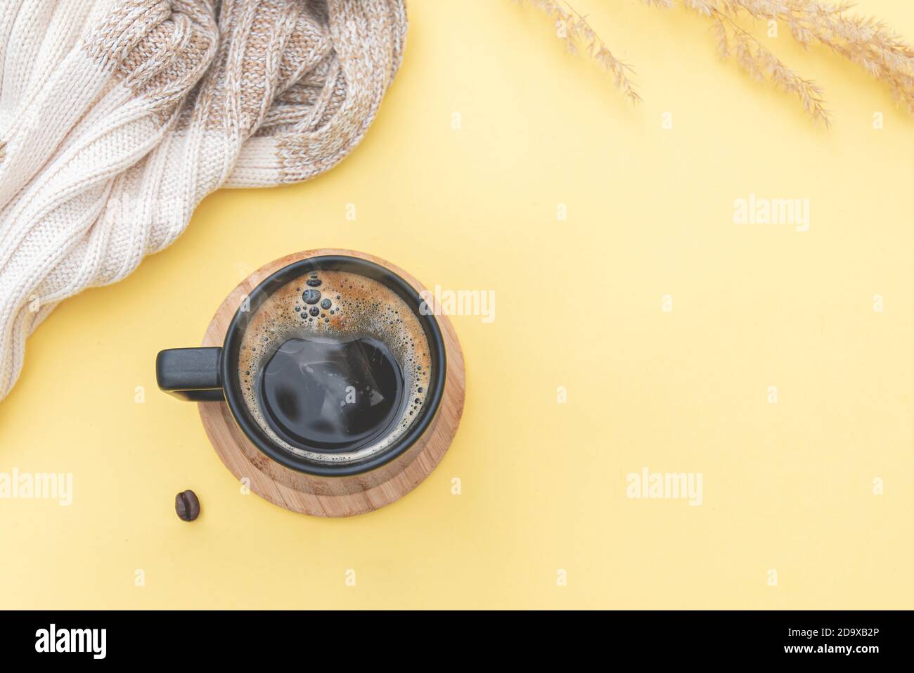Morning composition: scarf on table with coffee mug, coffee beans. layout with space for text and ideas. Autumn season Stock Photo