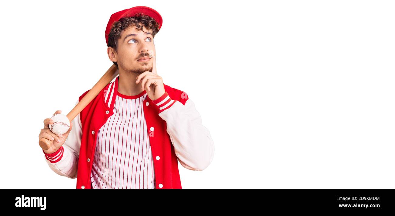 Young handsome man with curly hair playing baseball holding bat and