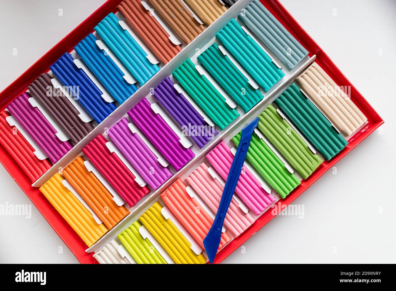 Rainbow colors plasticine box isolated on white background.Colorful kid's plasticine, dough modeling clay.Set of Soft colored wax clay.Copy space Stock Photo