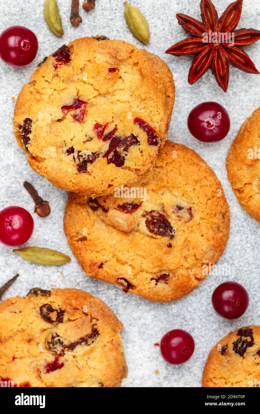 Freshly baked homemade cookies with cranberries, almonds, white chocolate and spices (cinnamon, cardamom, cloves, star anise) close-up. Oatmeal biscui Stock Photo