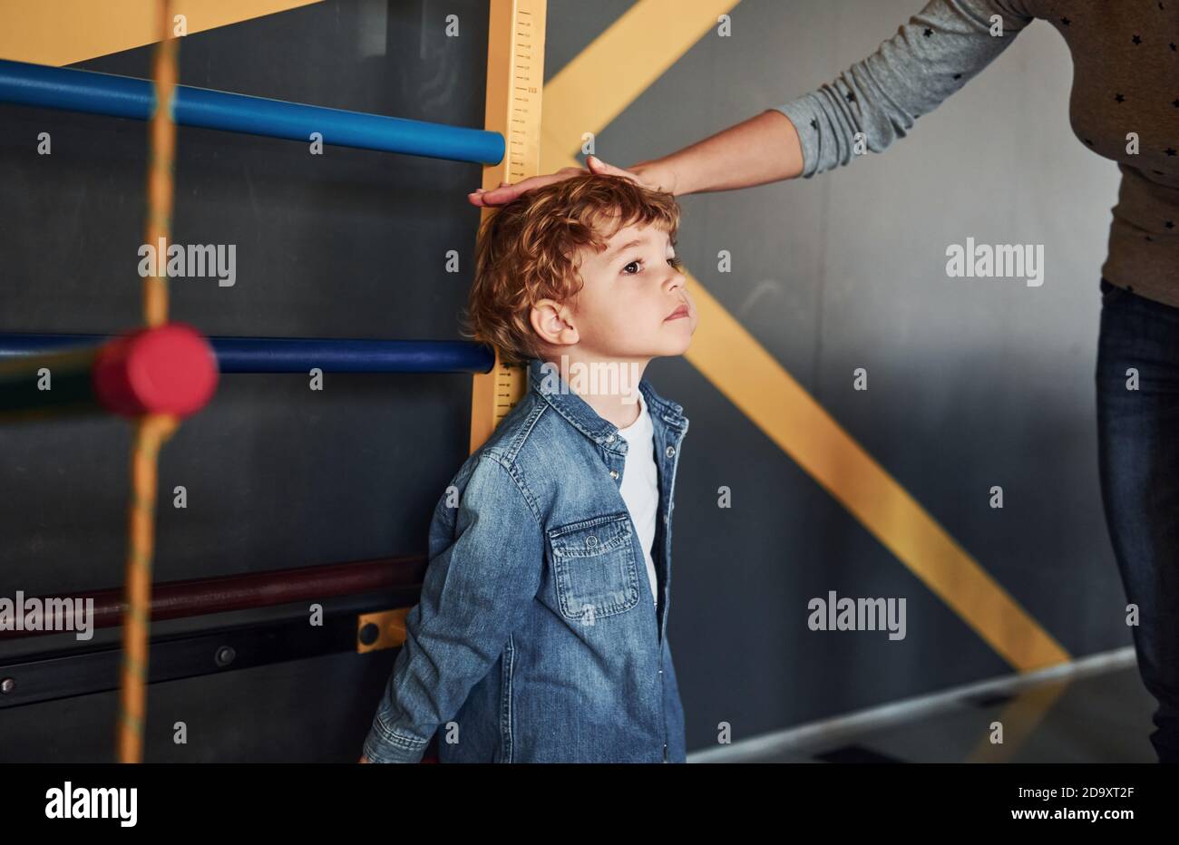 Teacher measuring kid's height indoors in kindergarten Stock Photo Alamy