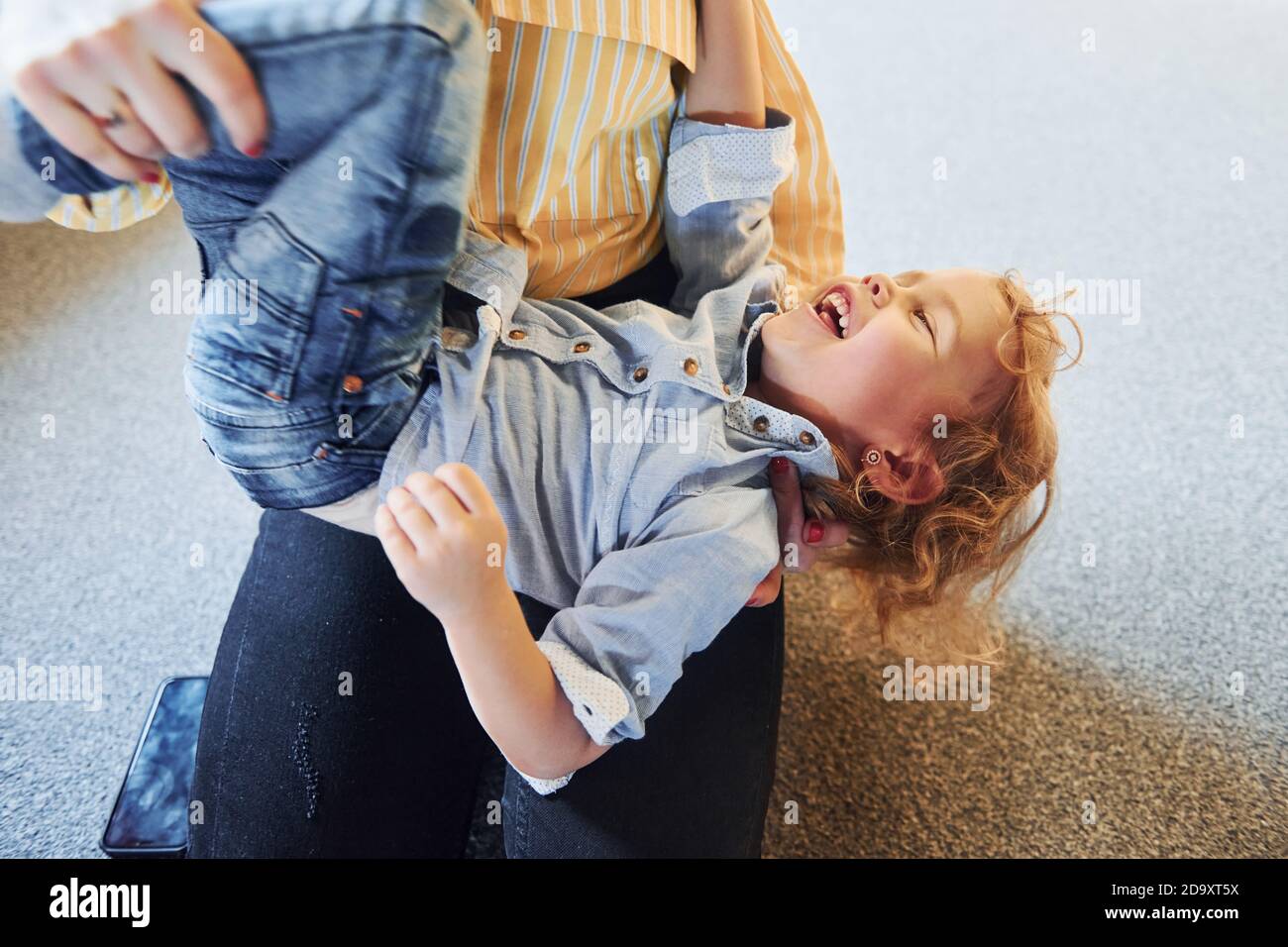 Child in jeans and casual clothes have fun indoors Stock Photo