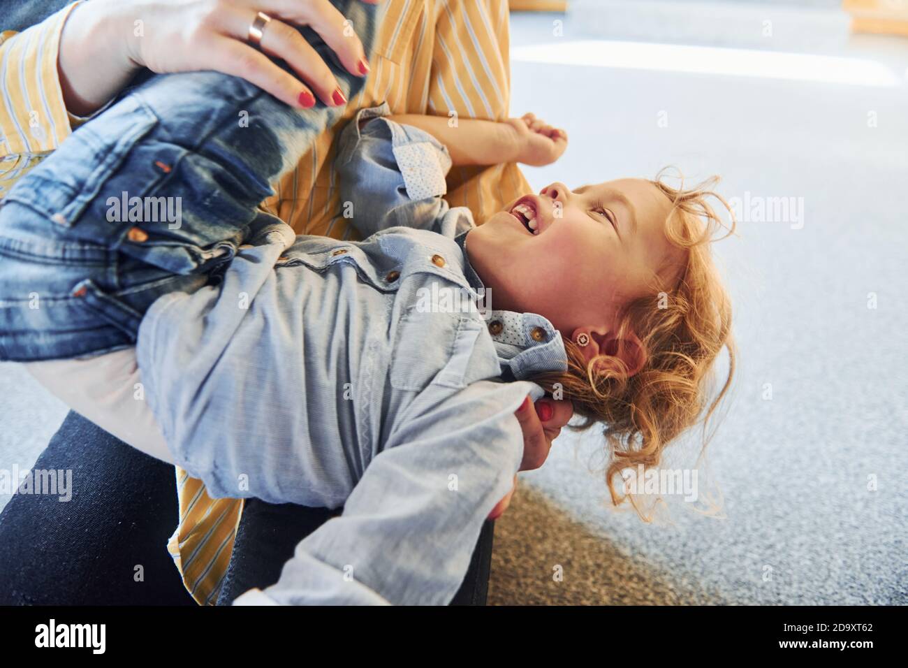 Child in jeans and casual clothes have fun indoors Stock Photo