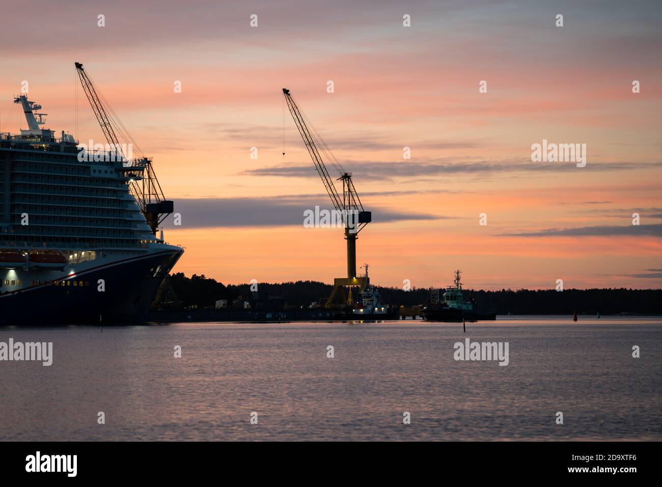 Bow of cruise ships and cranes at sunrise Stock Photo