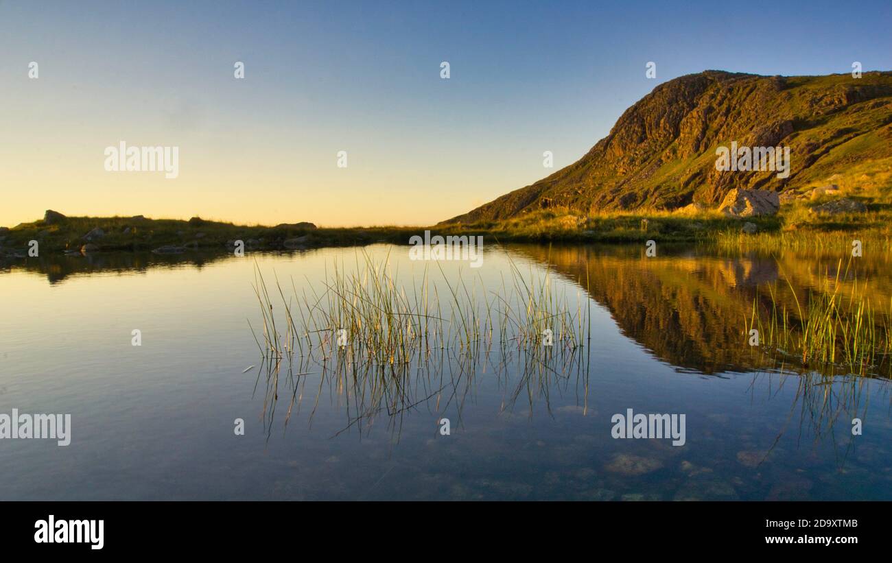 Mountains reflection: reflections of Bow Fell in a tarn , Langdale Valley, Lake District Stock Photo