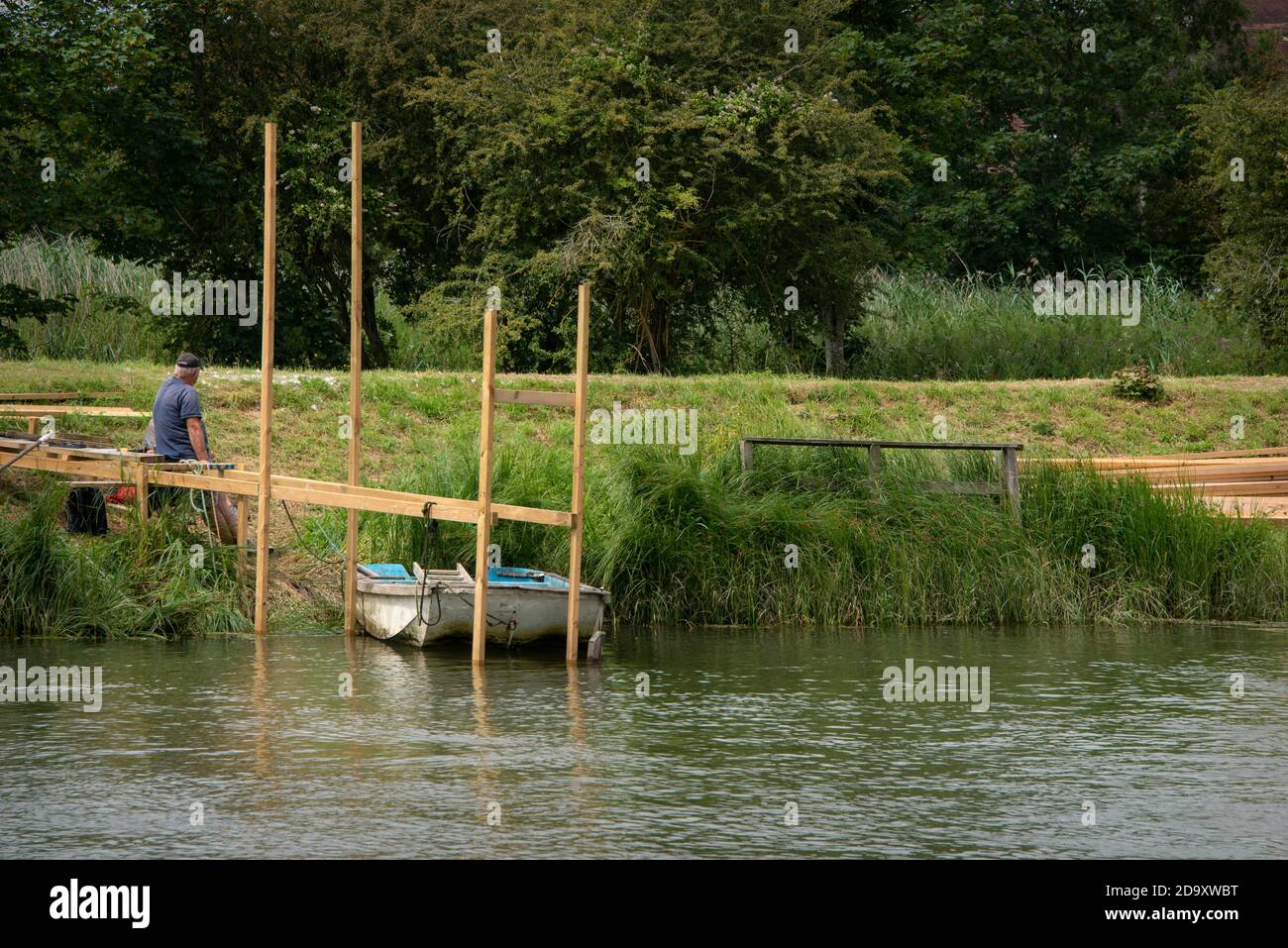Man resting whilst building a wooden pontoon on the River Arun, Arundel, West Sussex. Stock Photo