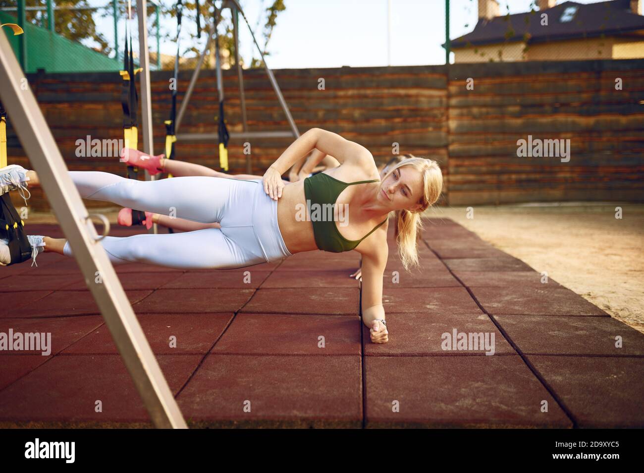 Women's group doing abs exercise outdoors Stock Photo