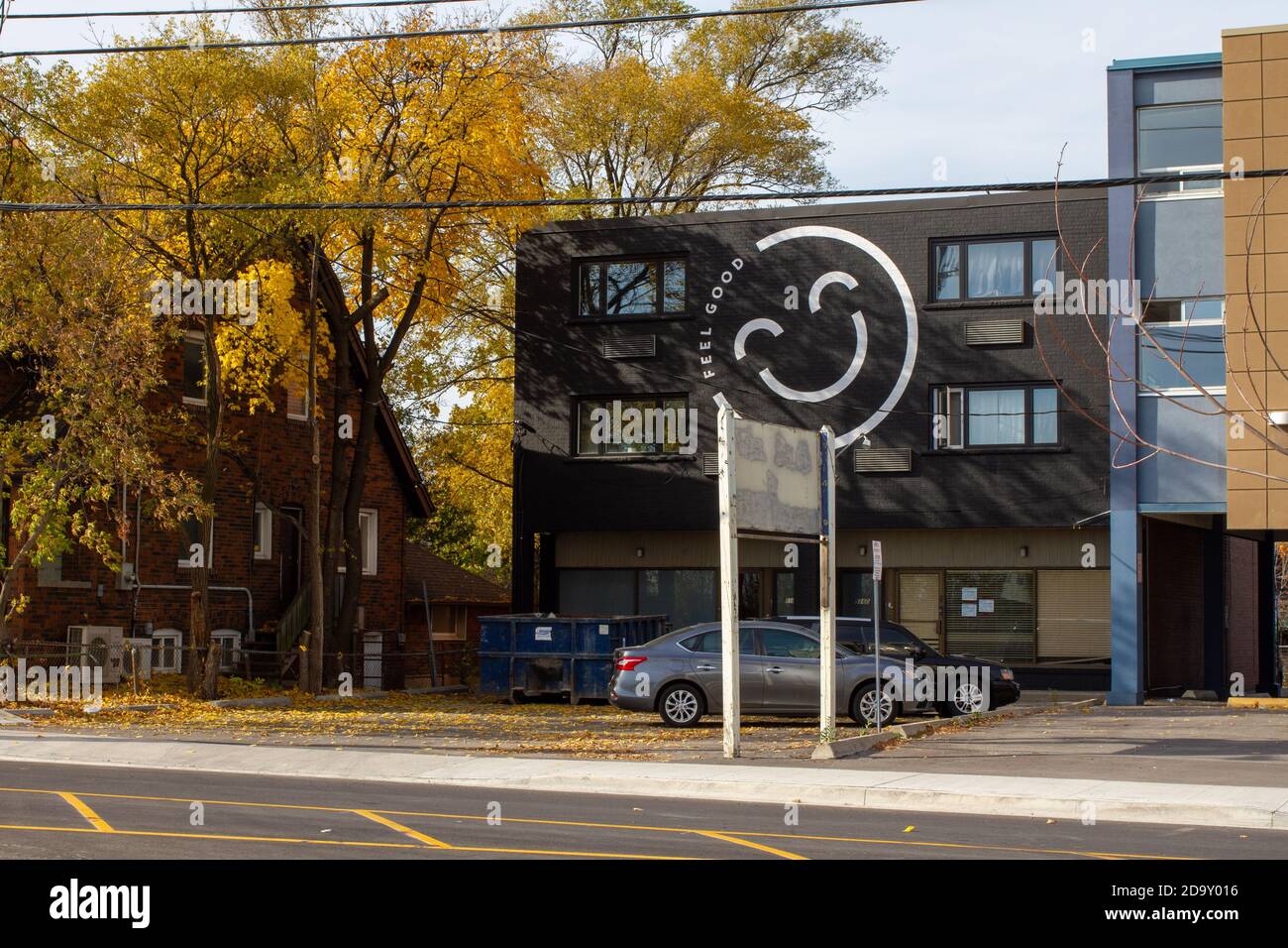 Mid rise retail building on Bloor Street West in Etobicoke, Ontario with a large smiley face painted on it. Stock Photo