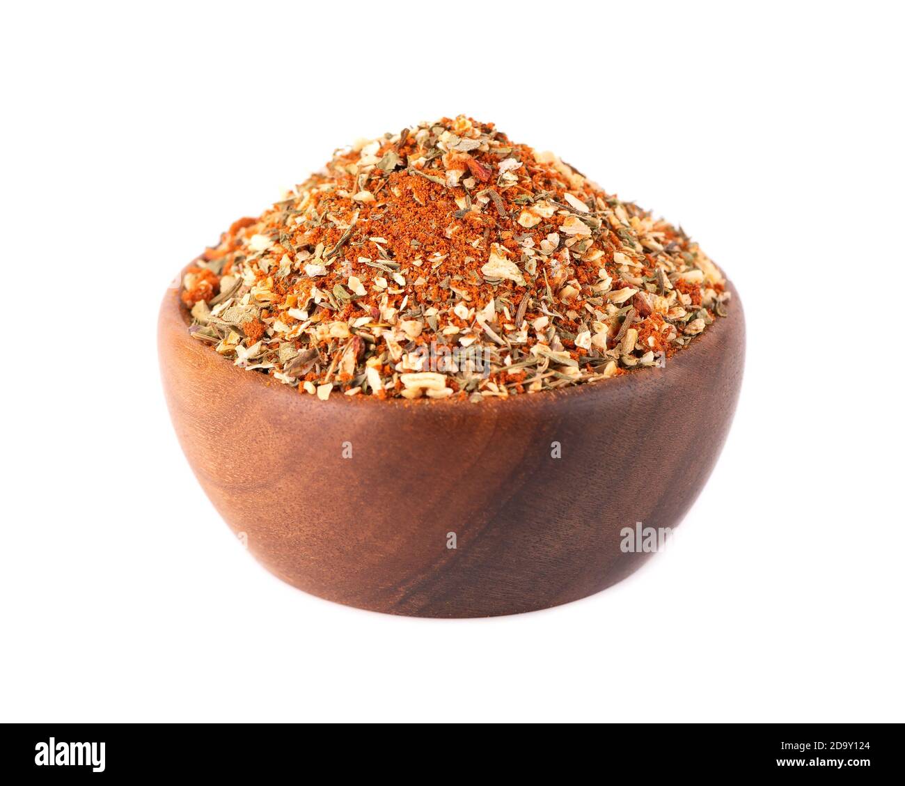 Mix of herbs, spices and dry tomatoes in wooden bowl, isolated on white