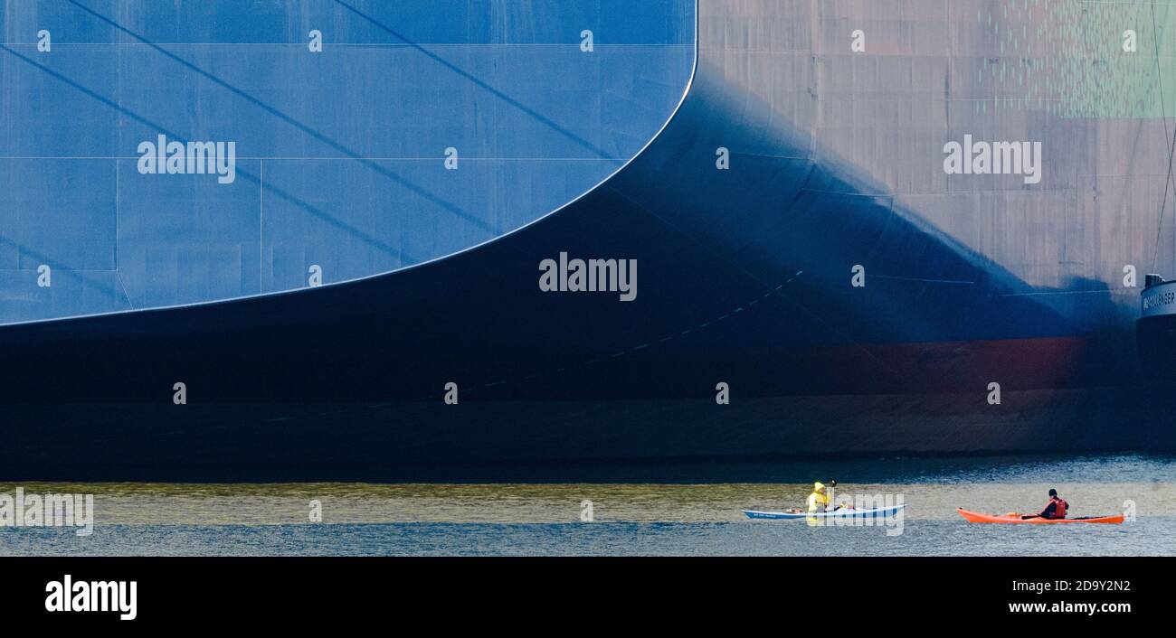 Hamburg, Germany. 08th Nov, 2020. Two kayakers paddle in front of the "CMA CGM Jacques Saade", the world's largest container ship powered by natural gas, which is unloading cargo at Burchardkai terminal for the first time. Credit: Markus Scholz/dpa/Alamy Live News Stock Photo