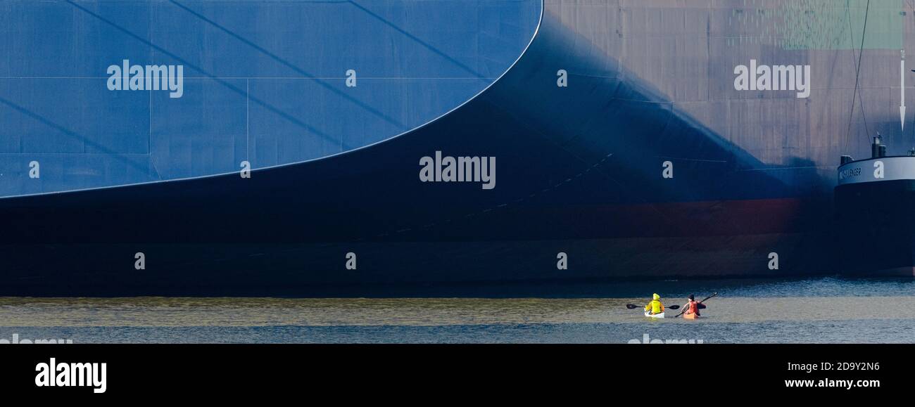 Hamburg, Germany. 08th Nov, 2020. Two kayakers paddle in front of the "CMA CGM Jacques Saade", the world's largest container ship powered by natural gas, which is unloading cargo at Burchardkai terminal for the first time. Credit: Markus Scholz/dpa/Alamy Live News Stock Photo