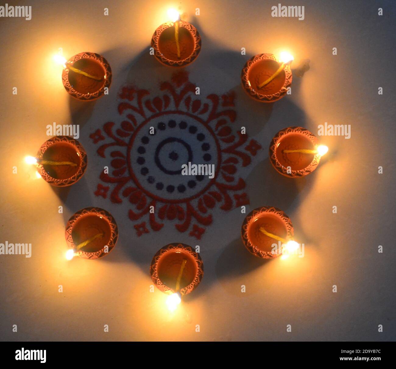 Powder rangoli surrounded by lit clay diyas' Diwali festival/India