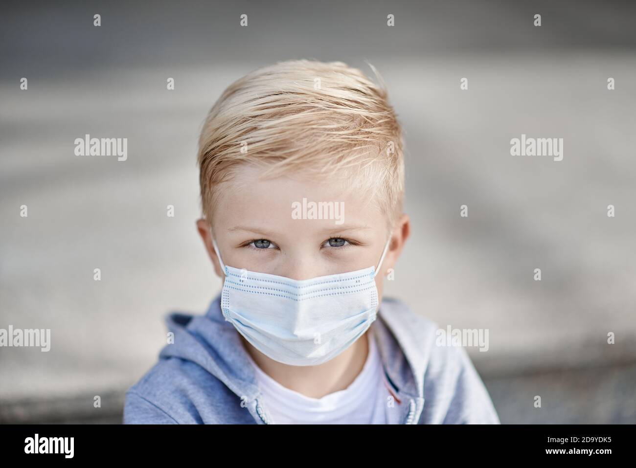 Child with face mask looking at us Stock Photo