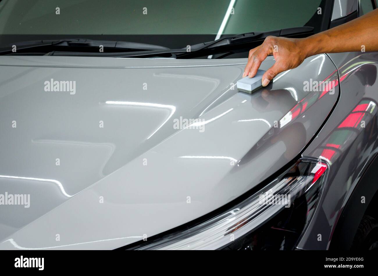 mechanic is coating ceramic glass to prevent scratches on cars Stock
